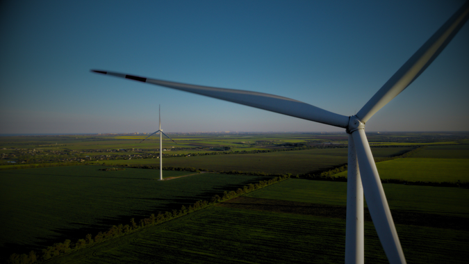 A wind turbine in the foreground, with wind tubrines in the background on a hill, the caption reads LCCC determines ILR and TRA for 2026 Q3